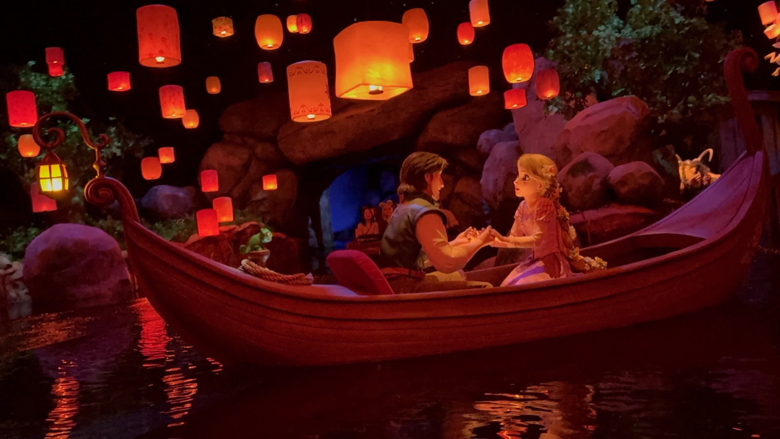 The Tangled lantern scene at Tokyo Disney Sea — Rapunzel and Flynn in a wooden boat below a sky full of glowing paper lanterns